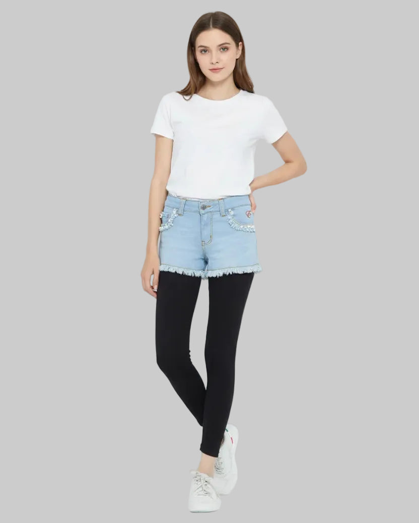 Person wearing black leggings, light blue denim shorts, and white sneakers on a white background