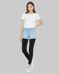 Woman wearing a white t-shirt, light blue denim shorts, and black leggings on a white background