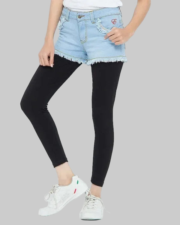 Person wearing black leggings, light blue denim shorts, and white sneakers on a white background