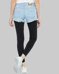 Person wearing light blue denim shorts and black leggings on a white background