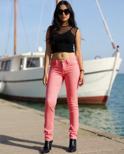 Woman wearing pink jeans and black top by a boat on a dock