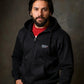 Man wearing a black hoodie with a logo on a dark background
