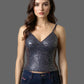 Woman wearing a sequined top and jeans against a neutral background