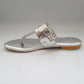 Silver sandal with chain detail on a gray background