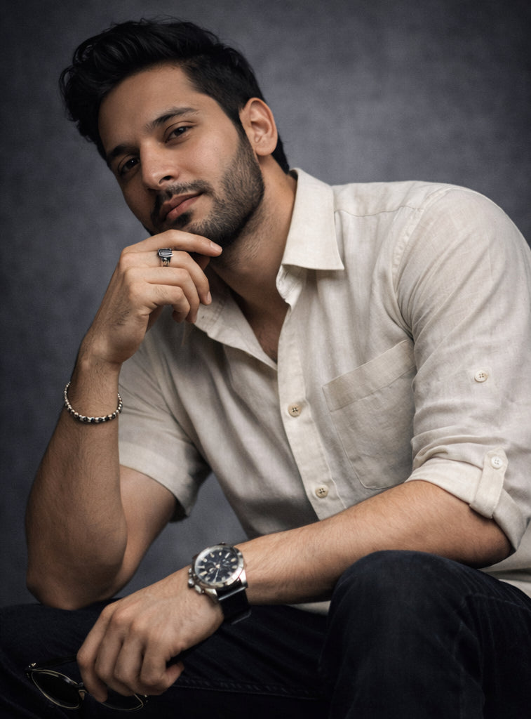 Man wearing a white short-sleeve shirt with buttons against a dark background
