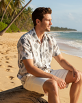 A short-sleeve button-up shirt with a gray and beige leaf pattern