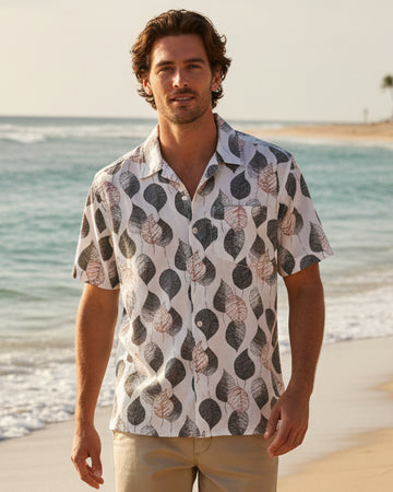 A short-sleeve button-up shirt with a gray and beige leaf pattern 